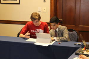 Two people educating each other at a conference table. 