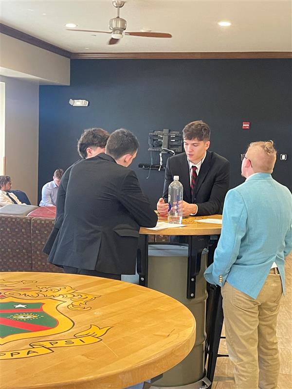 Four Phi Psis standing around table